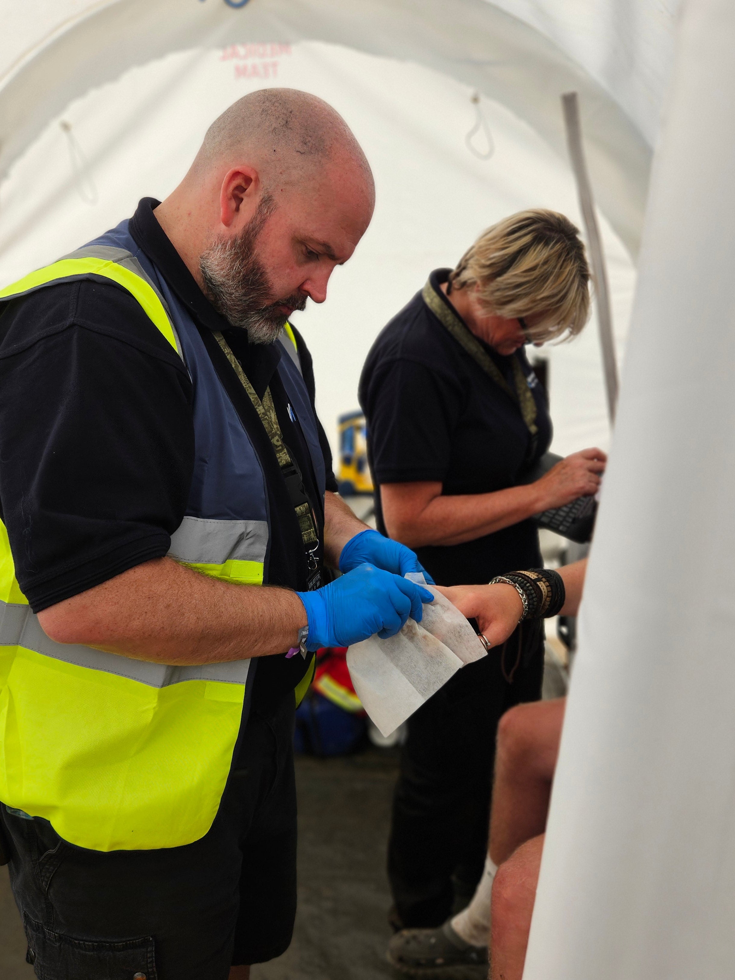 RSG medic in a hi-vis vest providing care to a patient in a portable facility.